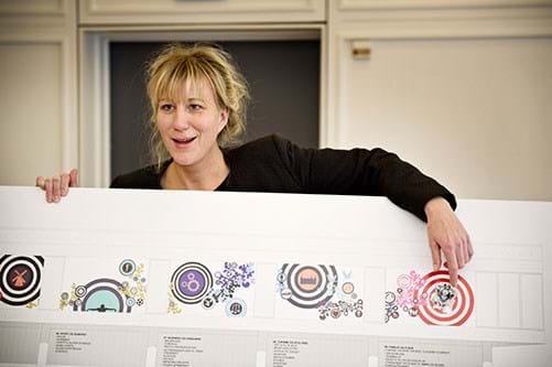Kunstner Louise Lagoni står med skitsen af de ni farverige felter, som skal byde gæster velkommen til byen. Foto Søren Hytting.
