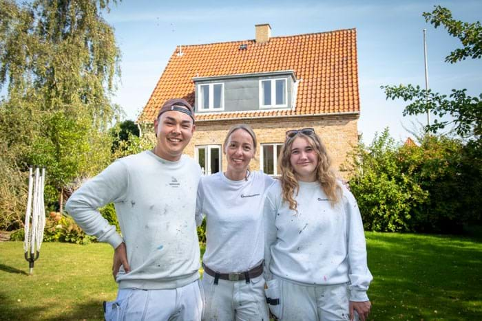 Lærlingene er glade, når vi kommenterer deres arbejde positivt. Vi løfter dem ved at rose dem – og så får vi bare et bedre forløb. Det tager lang tid at bygge den faglige selvtillid op, siger malermestrene Elisabeth Jørgensen og Jacob Jørgensen. Her Elisabeth Jørgensen sammen med Dennis Nicolaisen, tv., og Michell Helbæk Sørensen, th. Foto Søren Hytting.